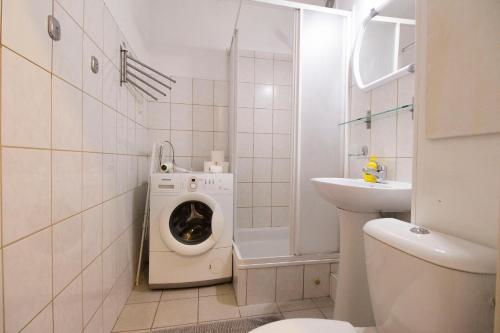a bathroom with a washing machine and a sink at Happy Apartments - Economy in Wrocław