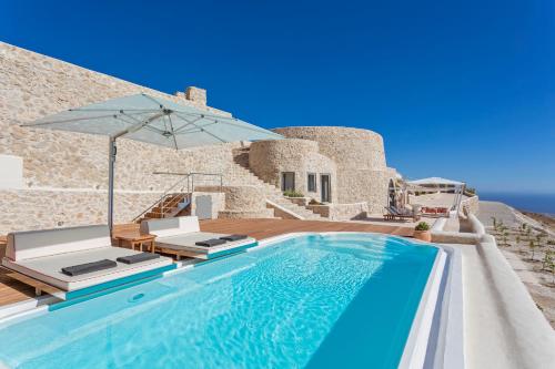 a villa with a swimming pool and an umbrella at Kamini Santorini Villas in Pyrgos