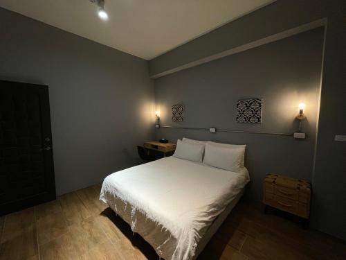 a bedroom with a white bed with two pillows at Taitung Sun forest in Taitung City