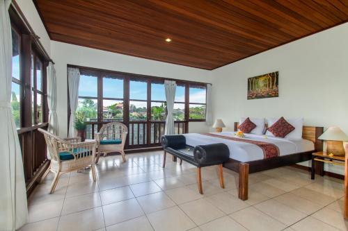 - une chambre avec un grand lit et un balcon dans l'établissement Sarin Ubud Suites by Pramana Villas, à Ubud