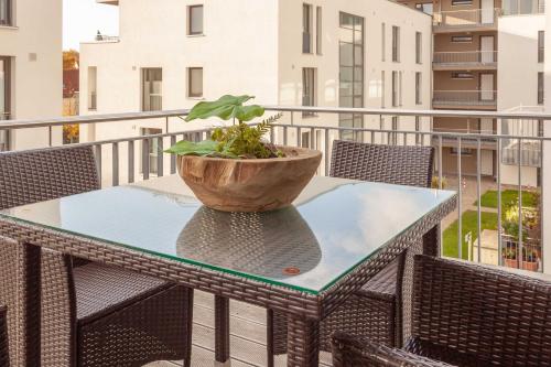 a table with a potted plant on a balcony at Appartement Strandläufer mit Südbalkon by Unsere Urlaubszeit in Binz