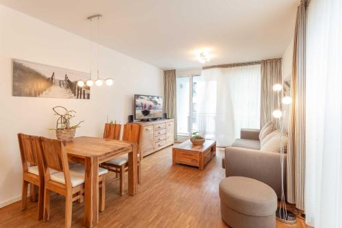 a living room with a table and a couch at Appartement Strandläufer mit Südbalkon by Unsere Urlaubszeit in Binz
