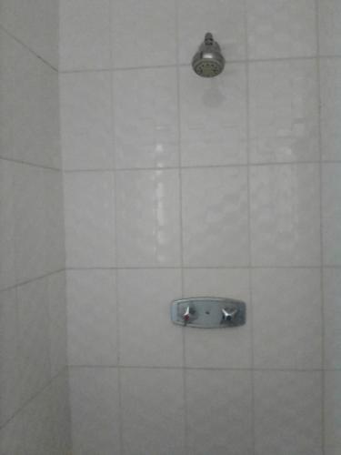 a white tiled shower with a light on it at Sugar Shack Backpackers Botswana in Gaborone