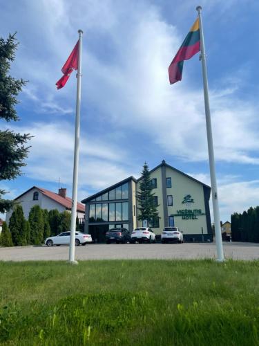 deux drapeaux dans l'herbe devant un bâtiment dans l'établissement Žilina, à Marijampolė