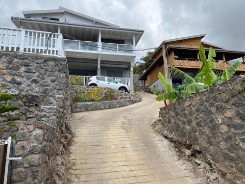 a stone retaining wall next to a house at Le Belvédère - Meublé 4 étoiles in Saint-Leu