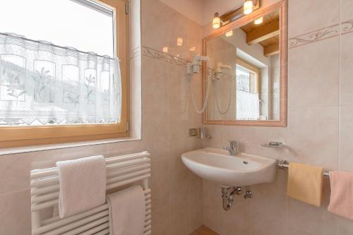 a bathroom with a sink and a mirror at B&B Apartments La Palsa in San Cassiano