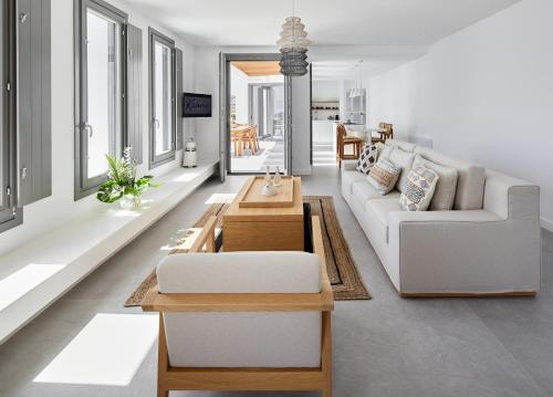 een woonkamer met een witte bank en een tafel bij Kamini Santorini Villas in Pirgos