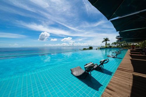 a swimming pool with a view of the ocean at The Reef Island Resort Mactan, Cebu in Mactan