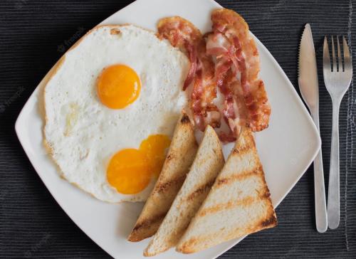 a plate of breakfast food with eggs bacon and toast at Malavi DV2 top center apartment Ruse in Ruse