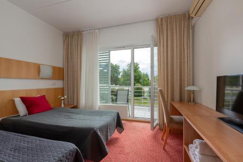 a hotel room with a bed and a television at Raadimõisa Hotell in Tartu