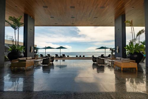 a lobby with tables and chairs and a beach at The Reef Island Resort Mactan, Cebu in Mactan