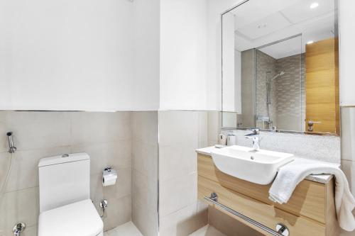 a bathroom with a sink and a toilet and a mirror at Fully Furnished Studio - 70m from Metro Station in Dubai