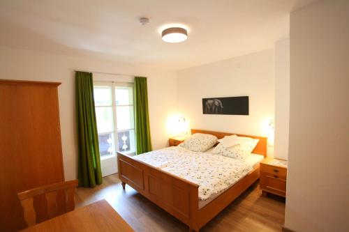 um quarto com uma cama e uma janela em Ferienwohnung Alpenblume Königssee em Schönau am Königssee