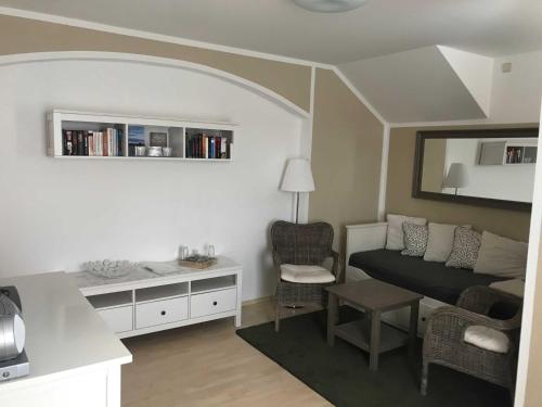 a living room with a couch and a desk with a chair at Ferienwohnung Eckloff in Lutherstadt Wittenberg