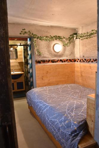 um quarto com uma cama com um edredão azul em Pyramide de Cormatin, 2 nuits minimum em Cormatin