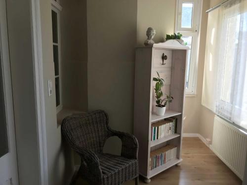 a room with a chair and a book shelf at Ferienwohnung Eckloff in Lutherstadt Wittenberg