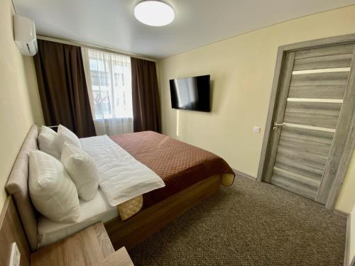 ポルタヴァにあるYavirのベッドとテレビが備わるホテルルームです。