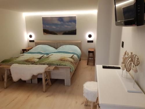 1 dormitorio con 1 cama y TV en una habitación en Nieuw app met tuin en terras, gratis parking, aan zee, vlakbij Brugge en Duinbergen