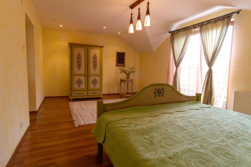 Vila cu Mesteceni في كامبينا: غرفة نوم بسرير اخضر ونافذة