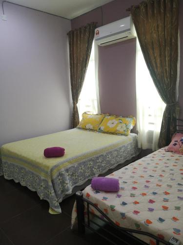 um quarto com 2 camas e uma janela em Kasih D'Sarina em Jitra