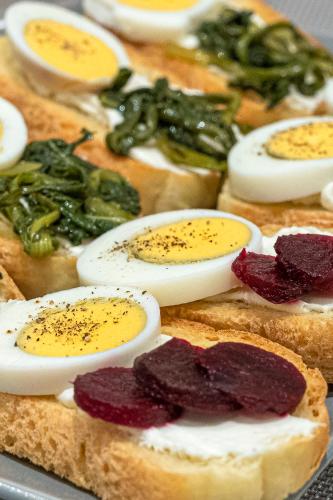 a bunch of bread with eggs and peppers on it at Hotel @Syngrou Fix in Athens