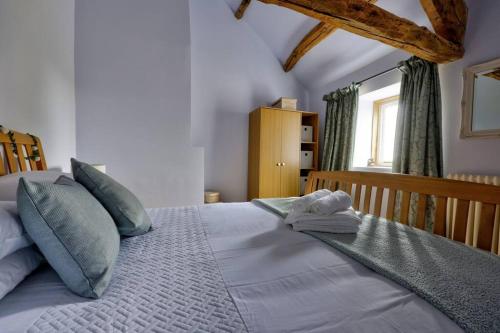 a bedroom with a large bed with blue pillows at Swans Farm in Lancaster