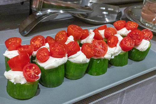 a tray of cupcakes with tomatoes and whipped cream at Hotel @Syngrou Fix in Athens