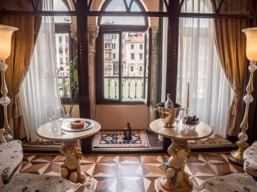 un soggiorno con due tavoli e una finestra di EGO' Boutique Hotel - The Silk Road a Venezia