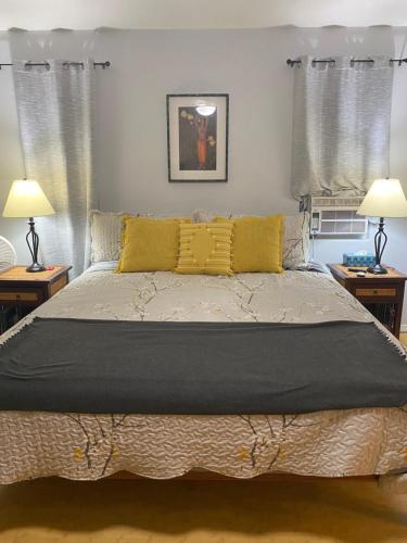 Un dormitorio con una cama grande con almohadas amarillas. en The cozy big studio -30 days, en Kailua-Kona