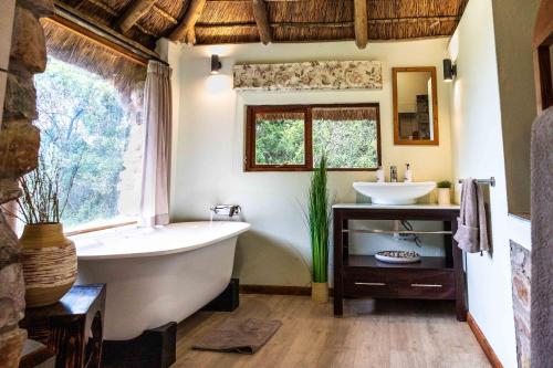 a bathroom with a tub and a sink at Woodbury Lodge – Amakhala Game Reserve in Amakhala Game Reserve