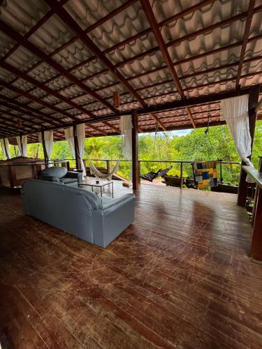 a living room with a couch on a wooden floor at Princesa de la Luna Ecolodge in Fortuna