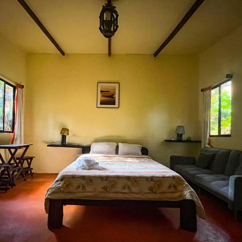 a bedroom with a large bed and a couch at Princesa de la Luna Ecolodge in Fortuna