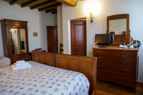 a bedroom with a bed and a dresser with a television at La Lepre Bianca in Cento