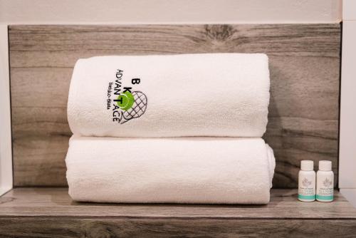 a stack of white towels on a wooden shelf at Tenis Park Advantage in Bielsko-Biala