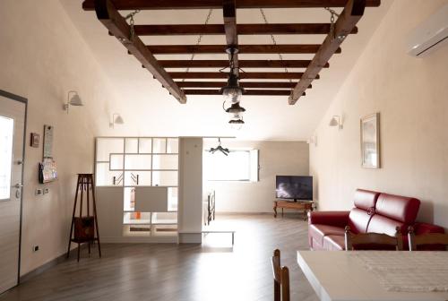 sala de estar con sofá rojo y mesa en Agriturismo Casa Chiara, en Latina