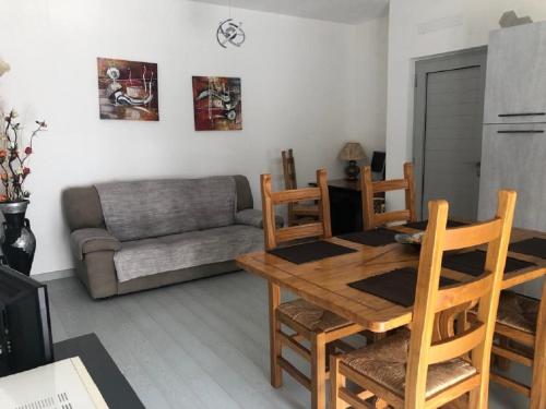 ein Wohnzimmer mit einem Tisch, Stühlen und einem Sofa in der Unterkunft Casa Bonelli in Alba