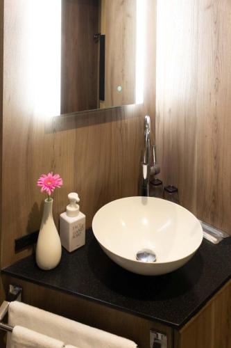a bathroom with a sink and a vase with a flower at Hotel Massimo Mishima in Mishima