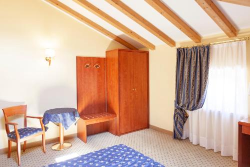 - une chambre avec un lit, une chaise et une armoire dans l'établissement Hotel Olivo, à Arco