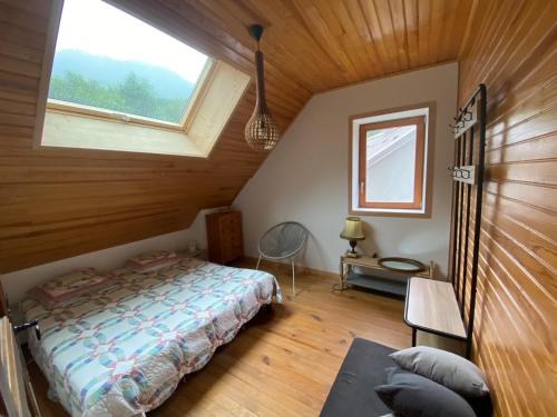 a bedroom with a bed in a room with a window at Locavilla - l'Estagnit in Puy-Saint-Eusèbe