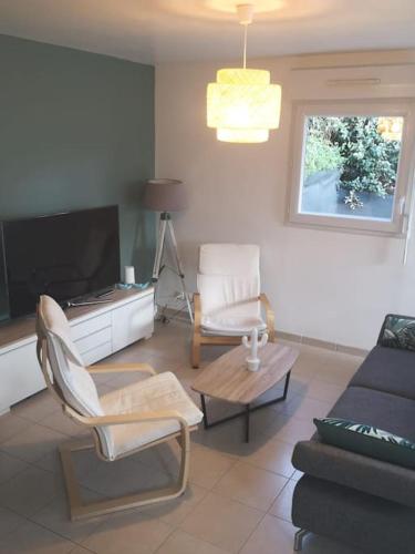 a living room with a couch and a tv at Mer et calme in Frehel