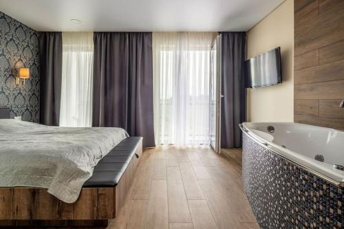 a bedroom with a bed and a bath tub at Prabangūs apartamentai su džiakuzi (Jacuzzi) in Klaipėda