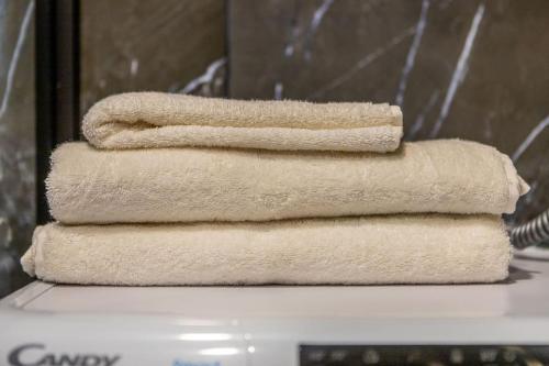 three towels stacked on top of each other in a bathroom at Prabangūs apartamentai su džiakuzi (Jacuzzi) in Klaipėda