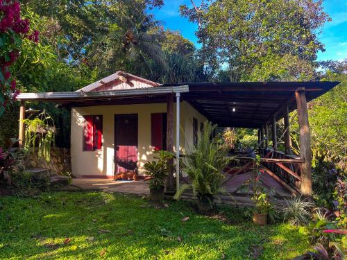 a small white house with a porch at Princesa de la Luna Ecolodge in Fortuna