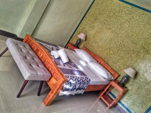 a bedroom with a bed and a chair at Calicoan Villa in Sarog