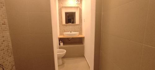 a bathroom with a toilet and a sink and a mirror at Marina apartment in Stoykite