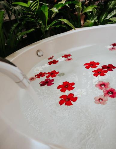 a group of red flowers in a bath tub at Shantaa Resort, Kohkood in Ko Kood