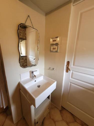 une salle de bain avec un lavabo blanc et un miroir dans l'établissement Authentiek landhuis met zwembad in Dordogne., à Goûts-Rossignols