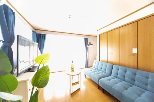 a living room with a blue couch and a table at Yokkaichi Motomachi Hotel in Yokkaichi