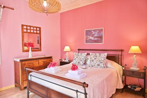 a bedroom with pink walls and a bed with flowers on it at Villa Ireni Waterfont in Fiskardho