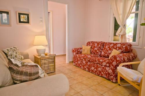a living room with a red couch and a chair at Villa Ireni Waterfont in Fiskardho